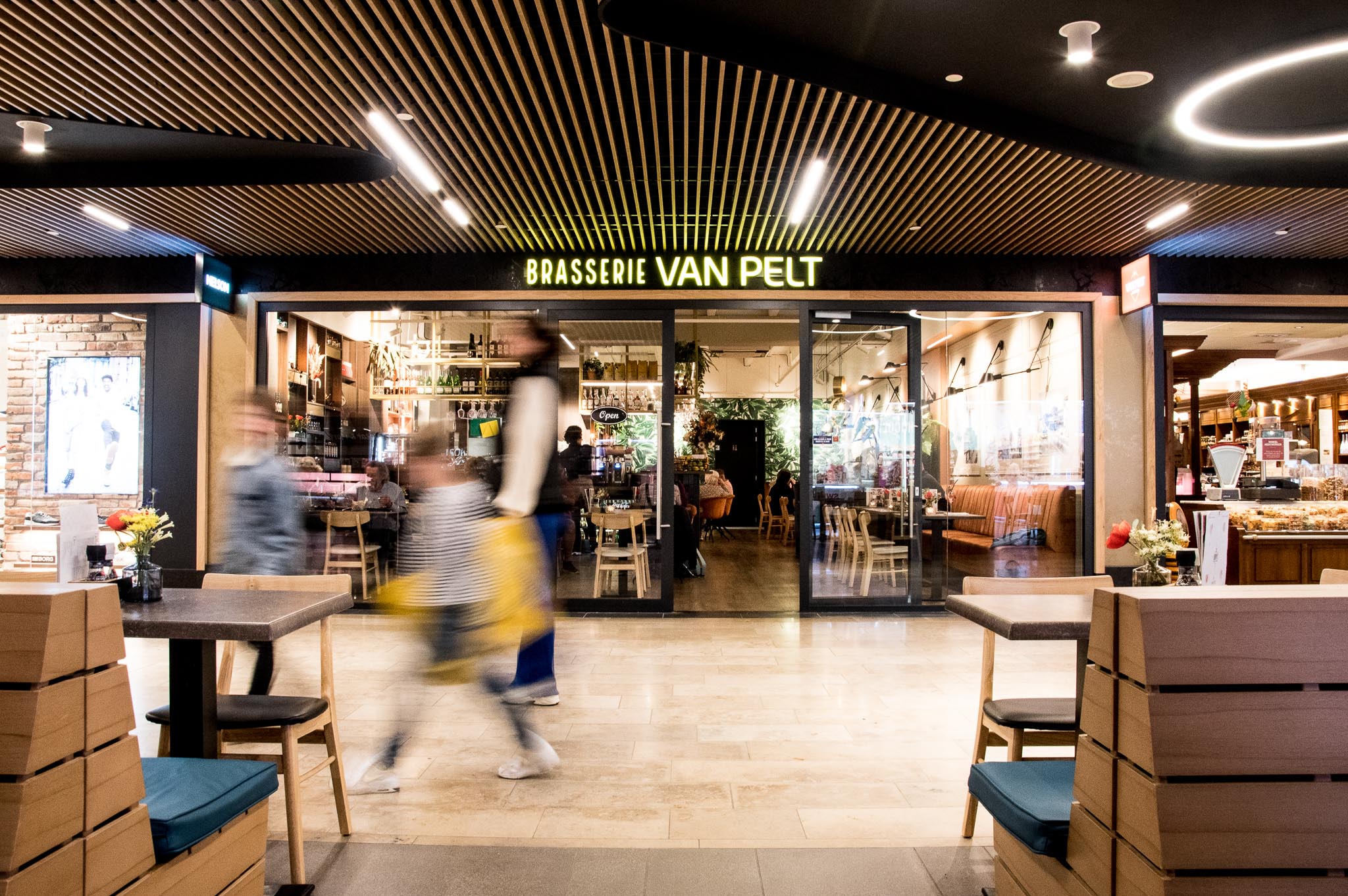 Winkelend publiek langs de entree van de brasserie Winkelend publiek langs de entree van de brasserie