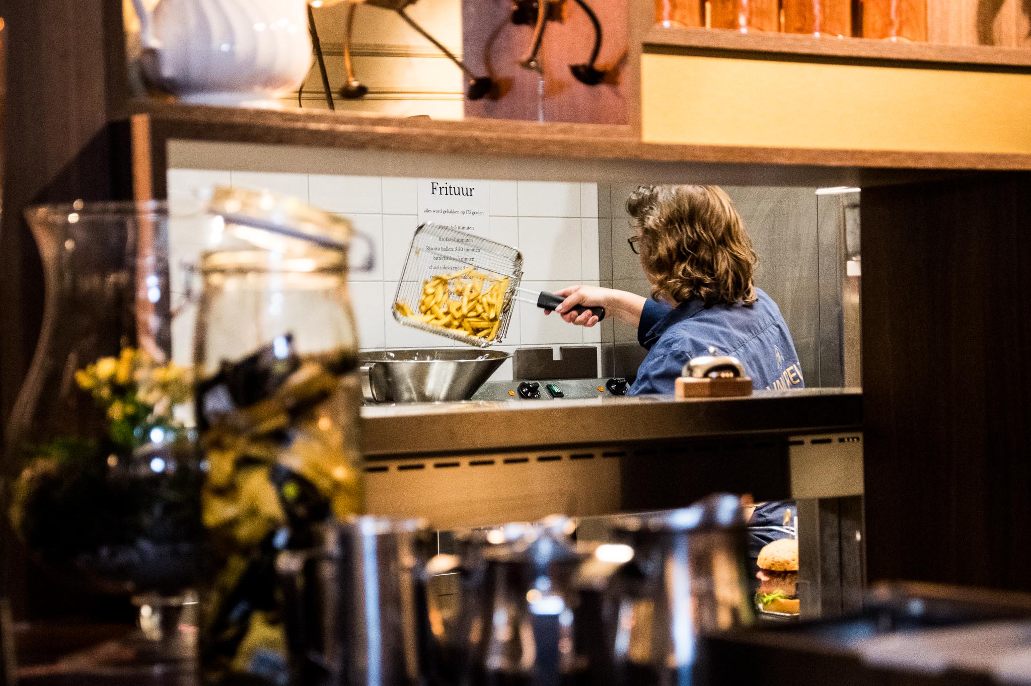 Persoon aan het werk in de keuken van de brasserie Persoon aan het werk in de keuken van de brasserie