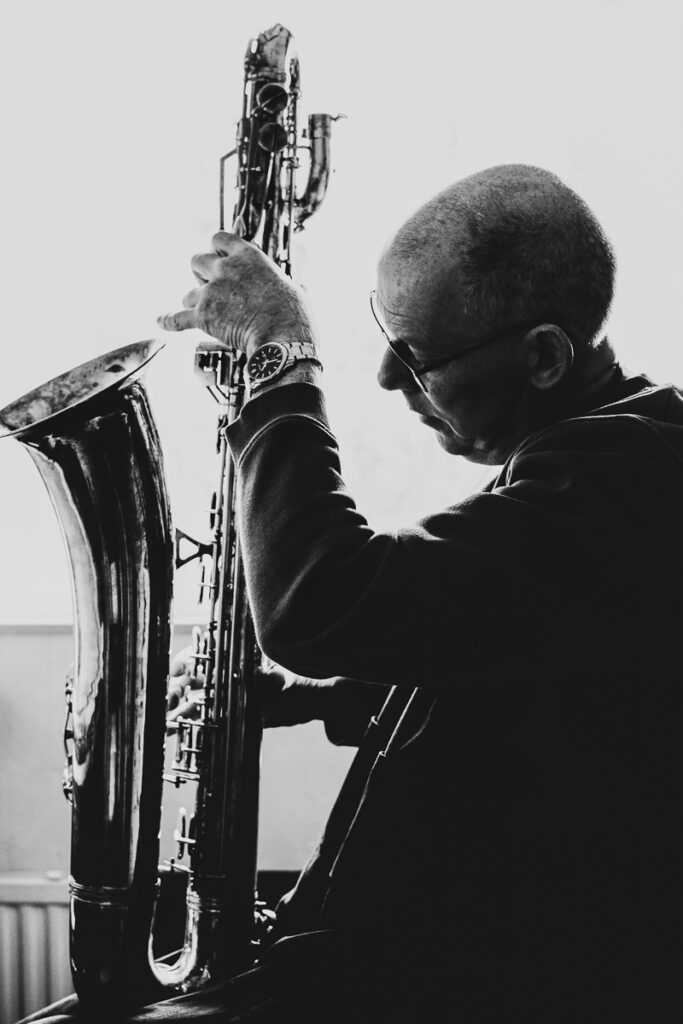 Zwartwit beeld van reparateur met saxofoon