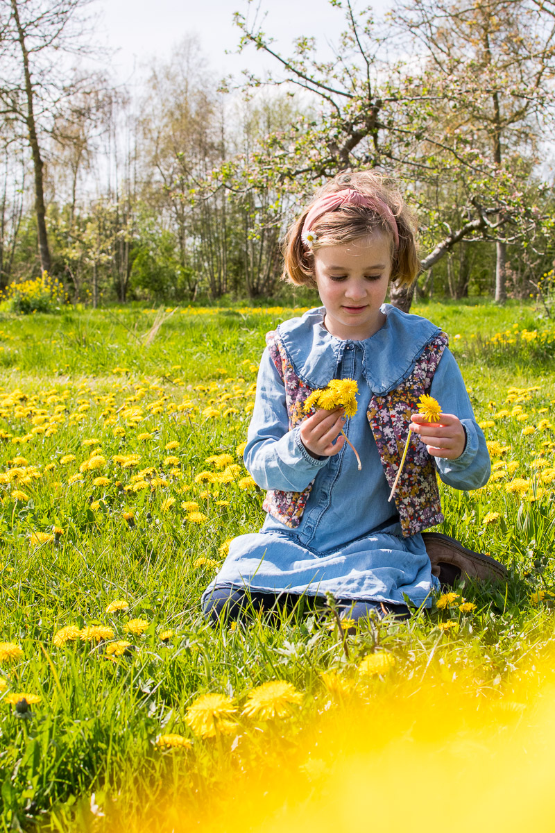 Kind speelt in bloemenveld tijdens fotoshoot Kind speelt in bloemenveld tijdens fotoshoot